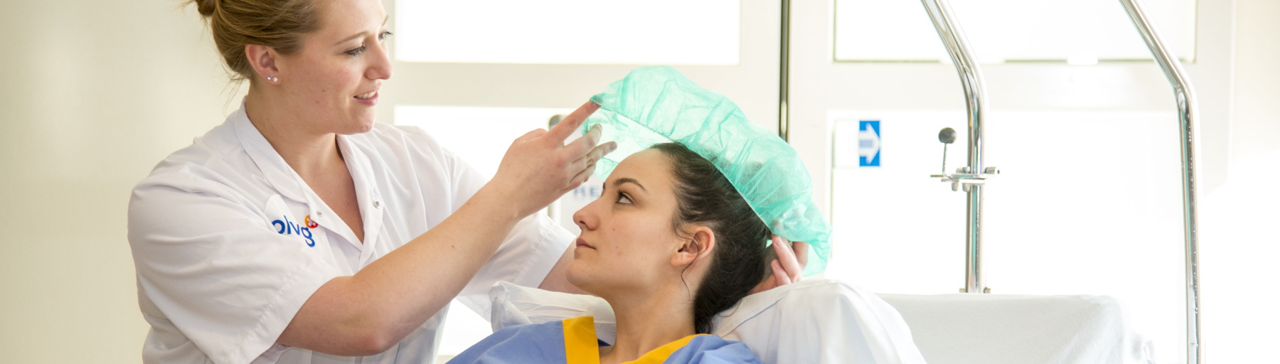 Zorgverlener zet een haarnetje op een patiënt