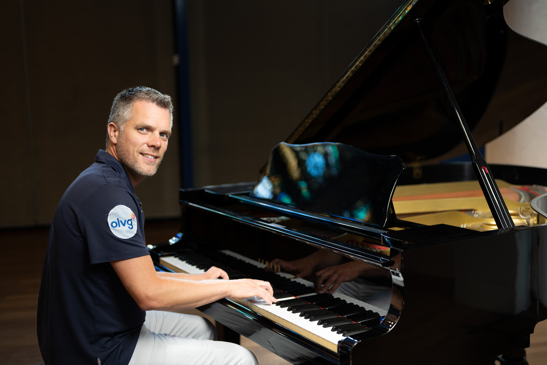 Fysiotherapeut Joep van Leeuwen zittend achter piano