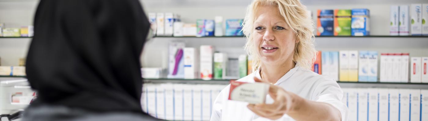 Foto van een apotheker en een patiënt