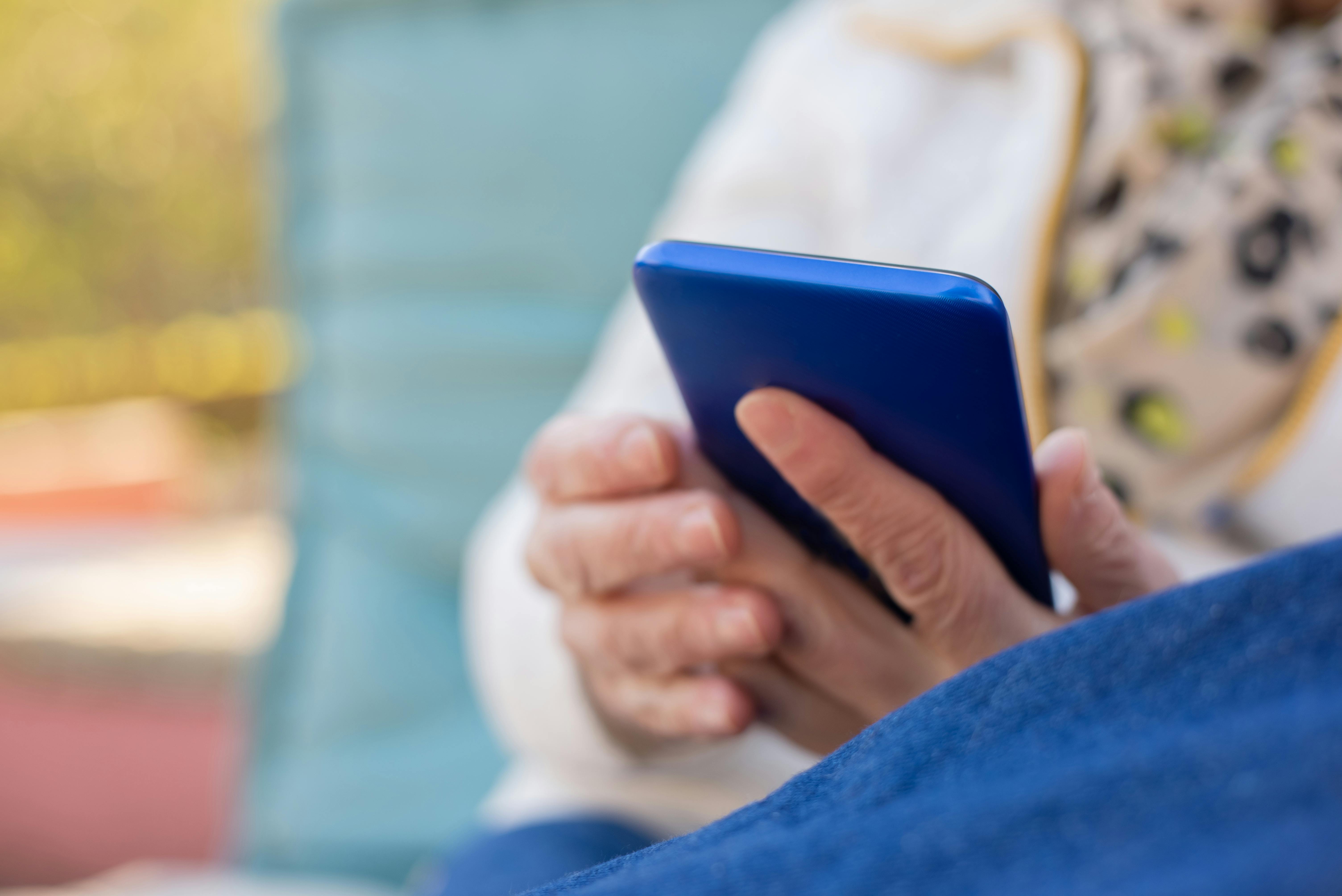 Ouder persoon met mobiele telefoon in de hand