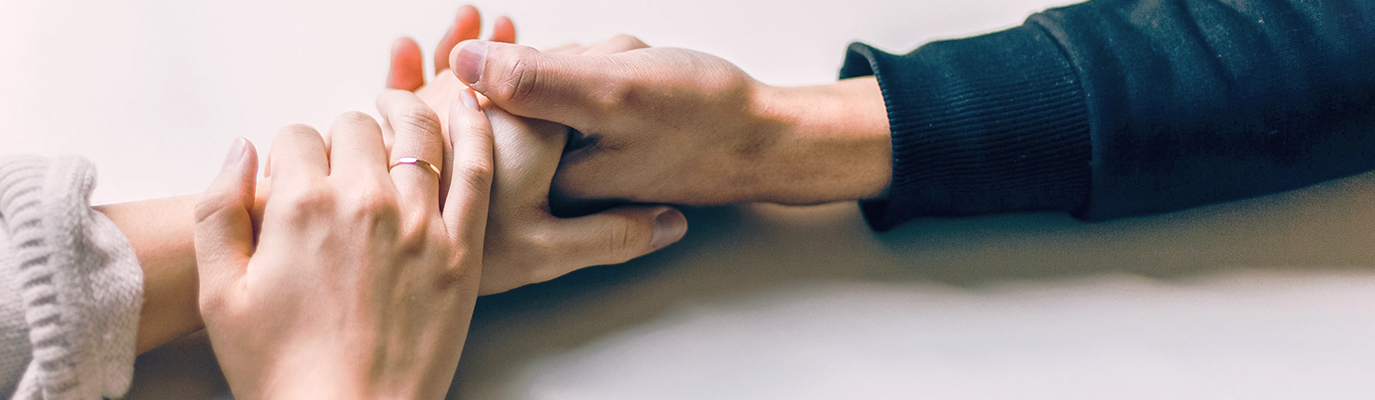 Foto van twee handen die elkaar vastpakken